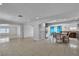 Spacious open-plan living area with tile floors and a view of the kitchen with a breakfast bar at 6882 Palmyra Ave, Las Vegas, NV 89146