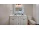 Bathroom featuring double sink vanity with modern fixtures, lighted mirror, and a toilet for convenience at 700 Cactus Ln, Las Vegas, NV 89107