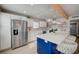 Beautiful kitchen with white cabinets, stainless steel appliances and a bold blue kitchen island at 700 Cactus Ln, Las Vegas, NV 89107