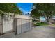 Backyard features two storage sheds adjacent to a concrete patio, grass lawn, and a large shade tree at 700 Cactus Ln, Las Vegas, NV 89107