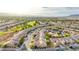 Extensive aerial view of a residential area featuring similar homes, tree-lined streets, and distant mountain views at 7556 Wingspread St, North Las Vegas, NV 89084