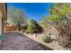 Landscaped backyard featuring decorative rocks, trees, and a low block wall at 7556 Wingspread St, North Las Vegas, NV 89084