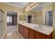 Bright bathroom featuring dual sinks and wood cabinets with views to the bedroom at 7556 Wingspread St, North Las Vegas, NV 89084