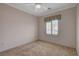 Cozy bedroom with neutral tones, a ceiling fan, and a window with privacy shutters at 7556 Wingspread St, North Las Vegas, NV 89084