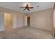 Spacious bedroom with neutral carpet and ceiling fan, offering comfortable living space at 7556 Wingspread St, North Las Vegas, NV 89084