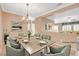 This virtually staged dining room features a wood table, seating for eight, and a stylish chandelier at 7556 Wingspread St, North Las Vegas, NV 89084