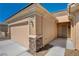 A charming entrance with stone accents, an attached two-car garage, and desert landscaping enhances curb appeal at 7556 Wingspread St, North Las Vegas, NV 89084