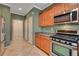 Traditional kitchen with stainless steel appliances, wood cabinetry, and tile flooring at 7556 Wingspread St, North Las Vegas, NV 89084