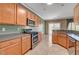 Traditional kitchen features stainless steel appliances, wood cabinetry, and tile floors at 7556 Wingspread St, North Las Vegas, NV 89084