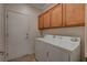 Functional laundry room with a washer, dryer, and overhead cabinets for storage at 7556 Wingspread St, North Las Vegas, NV 89084