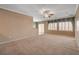 Empty living room features plantation shutters, carpet flooring, and neutral paint at 7556 Wingspread St, North Las Vegas, NV 89084