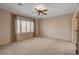 Carpeted main bedroom with a ceiling fan and plenty of natural light from the large window at 7556 Wingspread St, North Las Vegas, NV 89084