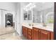 Bathroom with double vanity, granite counters, and shower behind sliding glass at 7641 Lani Dawn St, Las Vegas, NV 89149