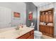 Cozy bathroom featuring a vanity with dark wood cabinets, a framed mirror, a toilet and decorative wall art at 7641 Lani Dawn St, Las Vegas, NV 89149