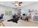 Bright bedroom featuring two windows, a ceiling fan, and versatile workspace perfect for a home office or hobby area at 7641 Lani Dawn St, Las Vegas, NV 89149