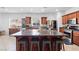 Spacious kitchen boasts dark wood cabinetry, stainless steel appliances, and a large center island with seating at 7641 Lani Dawn St, Las Vegas, NV 89149