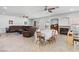 Spacious open-concept living room with tile flooring, ceiling fans, a fireplace and a dining table set for four at 7641 Lani Dawn St, Las Vegas, NV 89149