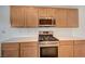 Close-up of a modern kitchen with stainless steel gas range, light wood cabinets and white countertops at 7760 Pine Warbler Way, North Las Vegas, NV 89084
