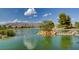 Beautiful pond view with island, rock waterfall, and mountain backdrop, offering a tranquil and scenic outdoor experience at 7760 Pine Warbler Way, North Las Vegas, NV 89084