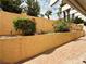 Lush backyard with a stucco wall providing privacy, features landscaping and outdoor lighting fixtures at 7821 Desert Bell Ave, Las Vegas, NV 89128