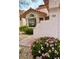 Charming home exterior with stucco walls, red tile roof, and colorful landscaping with pink flowers in the front at 7821 Desert Bell Ave, Las Vegas, NV 89128