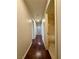 Hallway with hardwood floors leading to an open bathroom, featuring neutral wall colors and modern lighting at 7821 Desert Bell Ave, Las Vegas, NV 89128