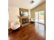 Comfortable living room with a brick fireplace, wood floors, ample natural light, and modern furnishings at 7821 Desert Bell Ave, Las Vegas, NV 89128