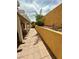 Exterior view of a covered patio with brick pavers and lush landscaping along a stucco wall at 7821 Desert Bell Ave, Las Vegas, NV 89128