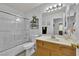 Bright bathroom featuring a shower with glass doors, toilet, and single sink with natural wood cabinets at 8009 Tailwind Ave, Las Vegas, NV 89131