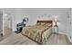 Bedroom featuring a patterned quilt, wood look floors and an elliptical machine at 8009 Tailwind Ave, Las Vegas, NV 89131