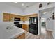 Functional kitchen with black appliances, light wood cabinets, and tile countertops at 8009 Tailwind Ave, Las Vegas, NV 89131