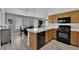 Kitchen featuring black appliances, light wood cabinets, and adjacent dining area at 8009 Tailwind Ave, Las Vegas, NV 89131