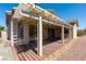 A partially covered patio area surrounded by landscape, flower bushes, and brick wall at 8249 Jo Marcy Dr, Las Vegas, NV 89131