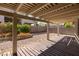 A partially covered patio area surrounded by landscape, flower bushes, and brick wall at 8249 Jo Marcy Dr, Las Vegas, NV 89131