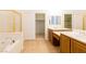 Bathroom featuring a tub, double sinks, and a walk-in closet, offering ample storage at 8249 Jo Marcy Dr, Las Vegas, NV 89131