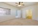 Carpeted bedroom with ceiling fan, and a connecting door to the bathroom and backyard entrance at 8249 Jo Marcy Dr, Las Vegas, NV 89131