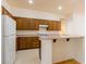 Well-lit kitchen featuring classic wood cabinetry, white appliances, and tile flooring at 8249 Jo Marcy Dr, Las Vegas, NV 89131