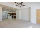 Spacious living room connects seamlessly to the kitchen with neutral color and a ceiling fan at 8249 Jo Marcy Dr, Las Vegas, NV 89131