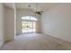 Sunlit living room featuring neutral carpet, vaulted ceiling, and sliding glass door access to patio at 8249 Jo Marcy Dr, Las Vegas, NV 89131