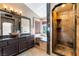 This primary bath features a vanity with dual sinks, walk-in shower and a soaking tub under a window at 8277 Mount Nido Dr, Las Vegas, NV 89147