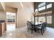Elegant dining room with a modern chandelier, large windows and seating for eight at 8277 Mount Nido Dr, Las Vegas, NV 89147