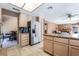 Open kitchen layout with stainless steel refrigerator and granite countertops leading into the living room at 8277 Mount Nido Dr, Las Vegas, NV 89147