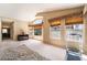 Spacious main bedroom with a treadmill, neutral carpeting, and several bright windows at 8277 Mount Nido Dr, Las Vegas, NV 89147