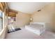 Vaulted ceiling and neutral carpeting are showcased in this main bedroom with a white bed frame and exercise equipment at 8277 Mount Nido Dr, Las Vegas, NV 89147
