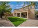 Beautiful backyard featuring a synthetic grass lawn, patio, and neutral-toned exterior of the home at 8537 Eureka Heights Ct, Las Vegas, NV 89178