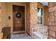 Inviting entryway featuring a wooden door, brick accents, and a welcoming bench at 8537 Eureka Heights Ct, Las Vegas, NV 89178