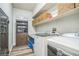 Well-equipped laundry room with modern washer and dryer, storage shelves and wooden cabinetry at 8537 Eureka Heights Ct, Las Vegas, NV 89178