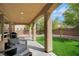 A covered patio with outdoor seating and a view of the landscaped backyard with artificial grass at 8537 Eureka Heights Ct, Las Vegas, NV 89178