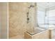 Modern shower with black hardware and tiled walls adjacent to tub and window at 8537 Eureka Heights Ct, Las Vegas, NV 89178
