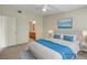 Virtually staged bedroom features plush bed, ocean art, and neutral carpet at 8725 W Flamingo Rd # 240, Las Vegas, NV 89147